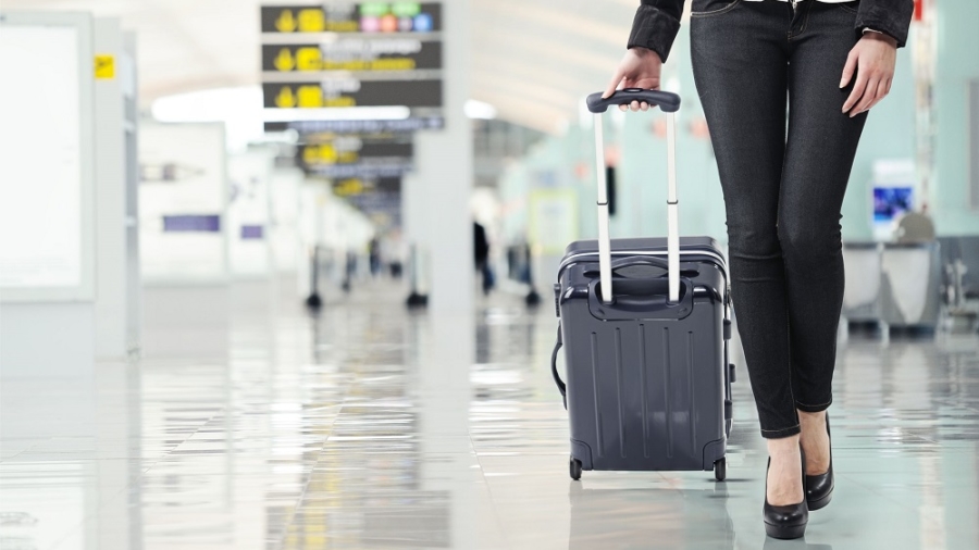 16661638 - young woman pulling luggage at the airport, close up sexy legs