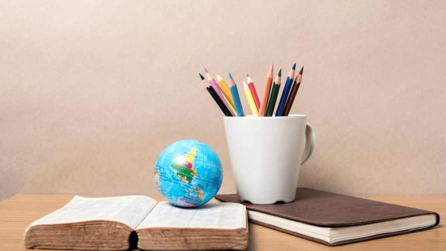 42422817 - book and earth ball with color pencil on wood background