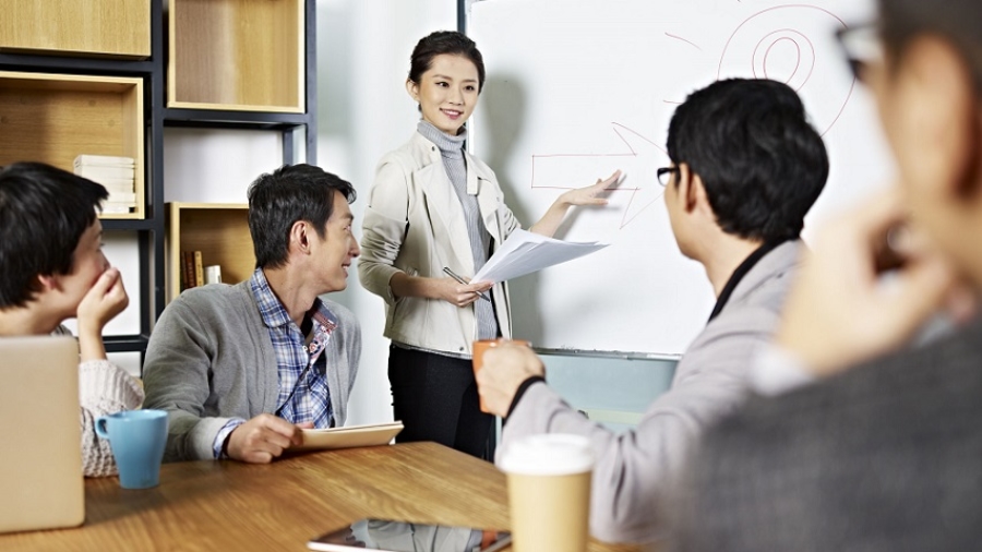 young asian business executive facilitating a discussion or brainstorm session in meeting room.