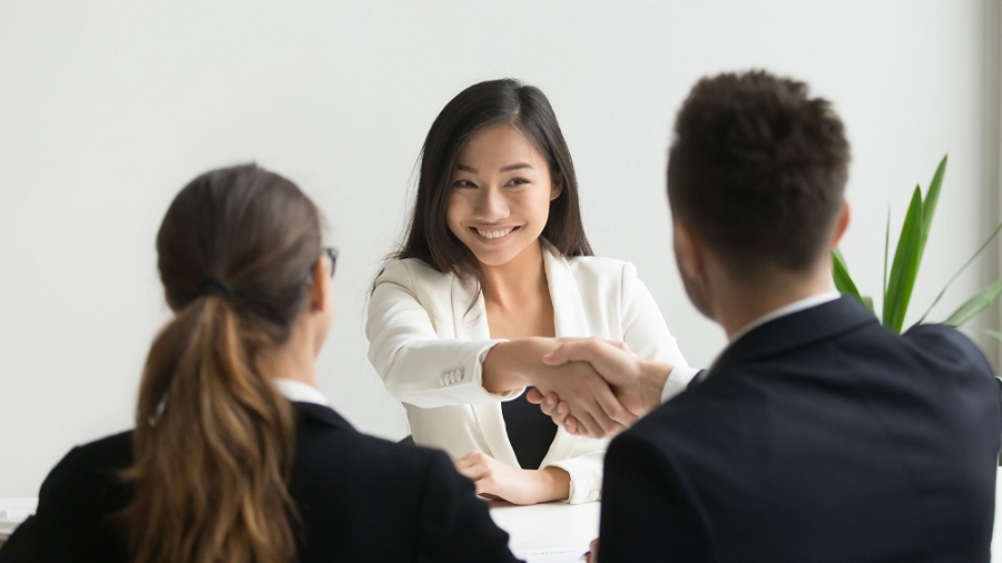 Happy millennial asian applicant getting hired shaking hand of hr, employer handshaking successful smiling chinese candidate congratulating with job interview win offering employment contract concept